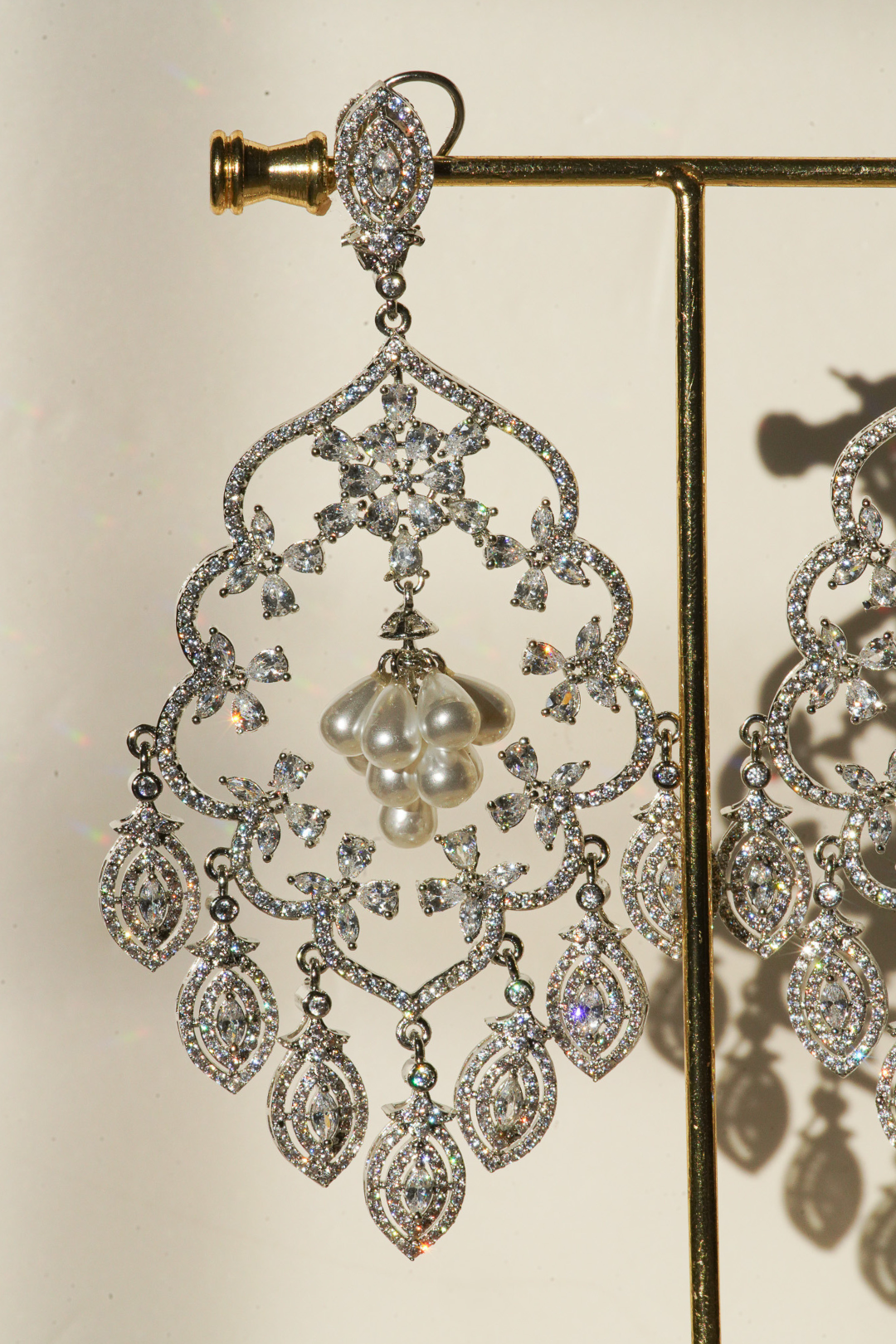 Julia Rhodium-Plated Statement Earrings with intricate detailing, 4.5-inch length, lightweight design, adorned with sparkling stones and pear-shaped dangles.