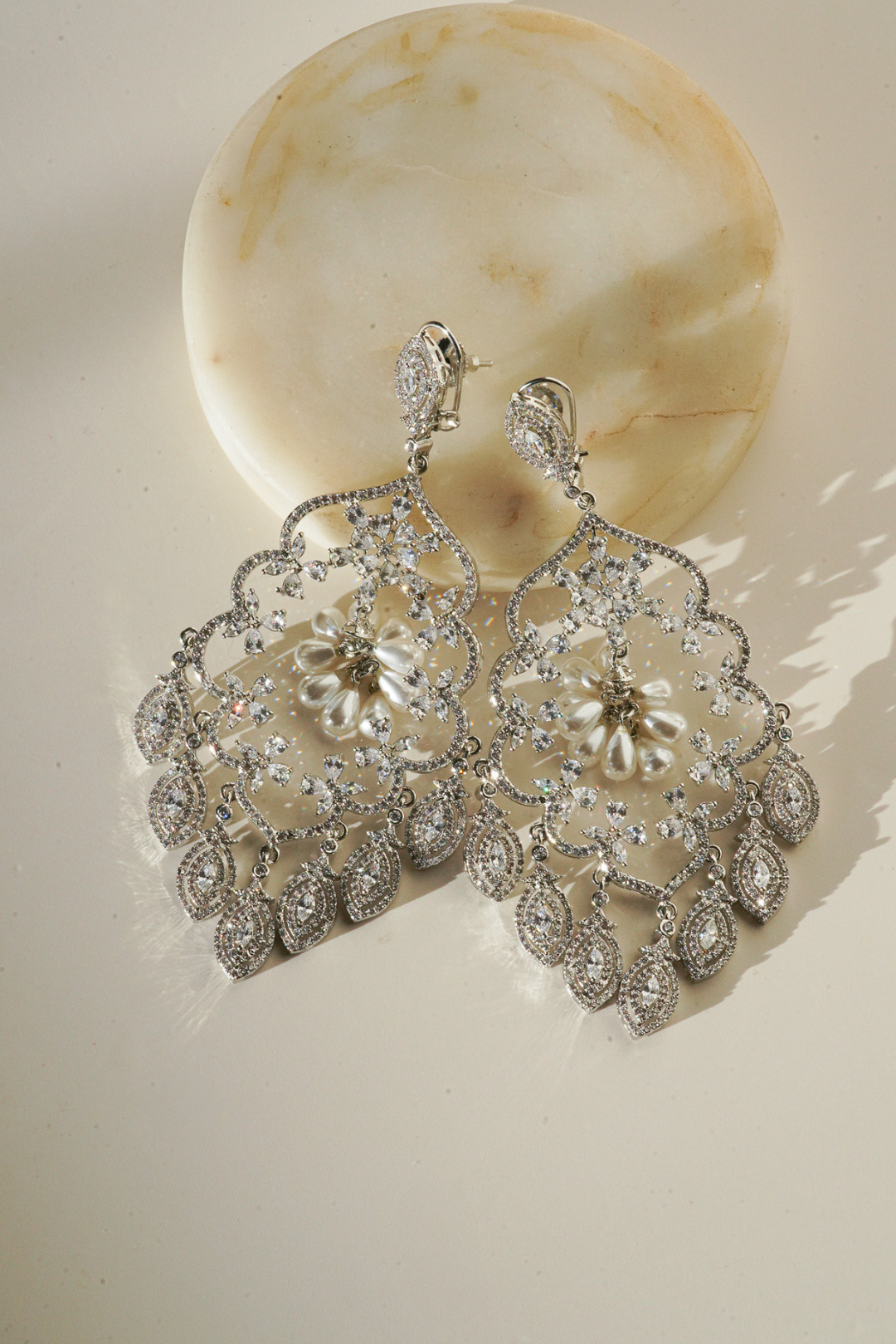 Julia Rhodium-Plated Statement Earrings with intricate detailing, 4.5-inch length, lightweight design, adorned with sparkling stones and pear-shaped dangles.