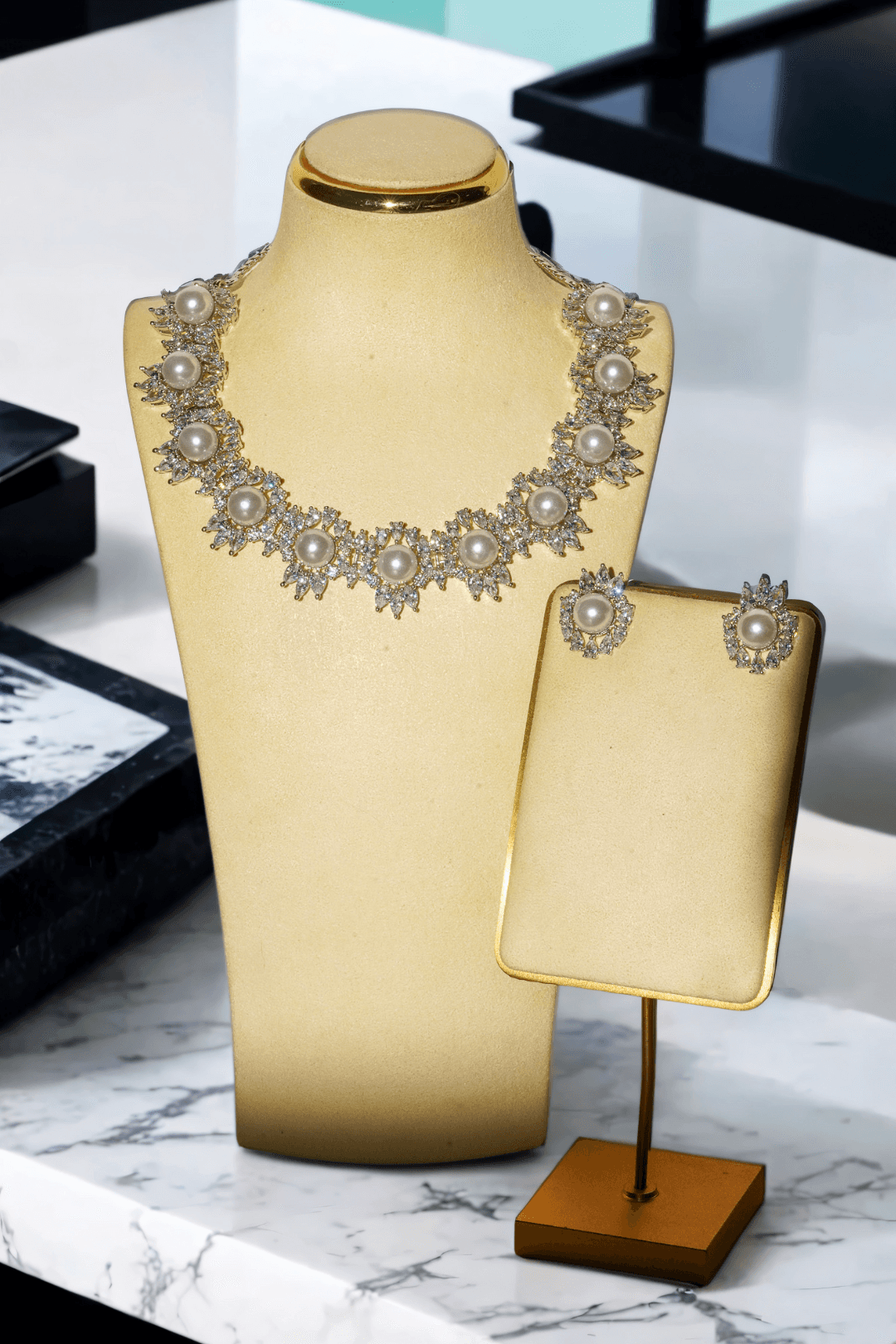 Mayesha Rhodium-Plated Pearl Cluster Necklace and Earring Set with luminous pearls and sparkling cubic zirconia clusters displayed on a cream jewelry stand.