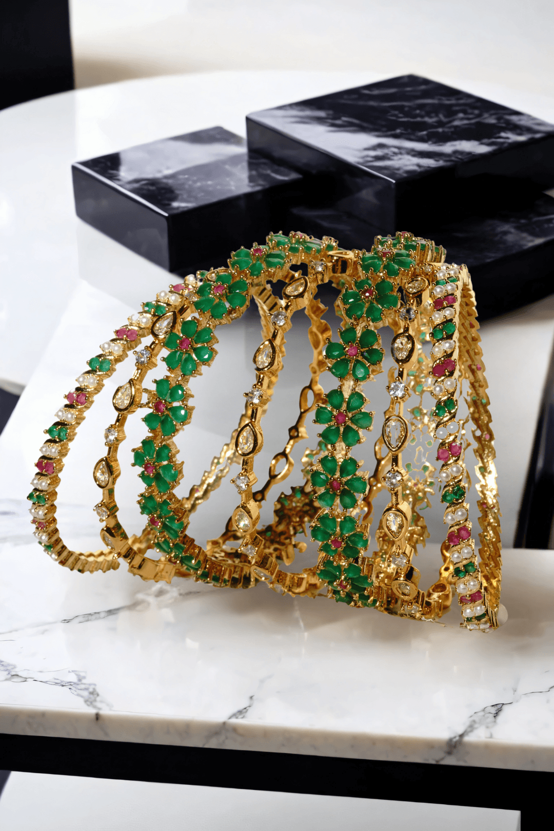 Meera 7-piece gold-plated bangle set with ruby and emerald accents from Inaury, floral design with diamante stones