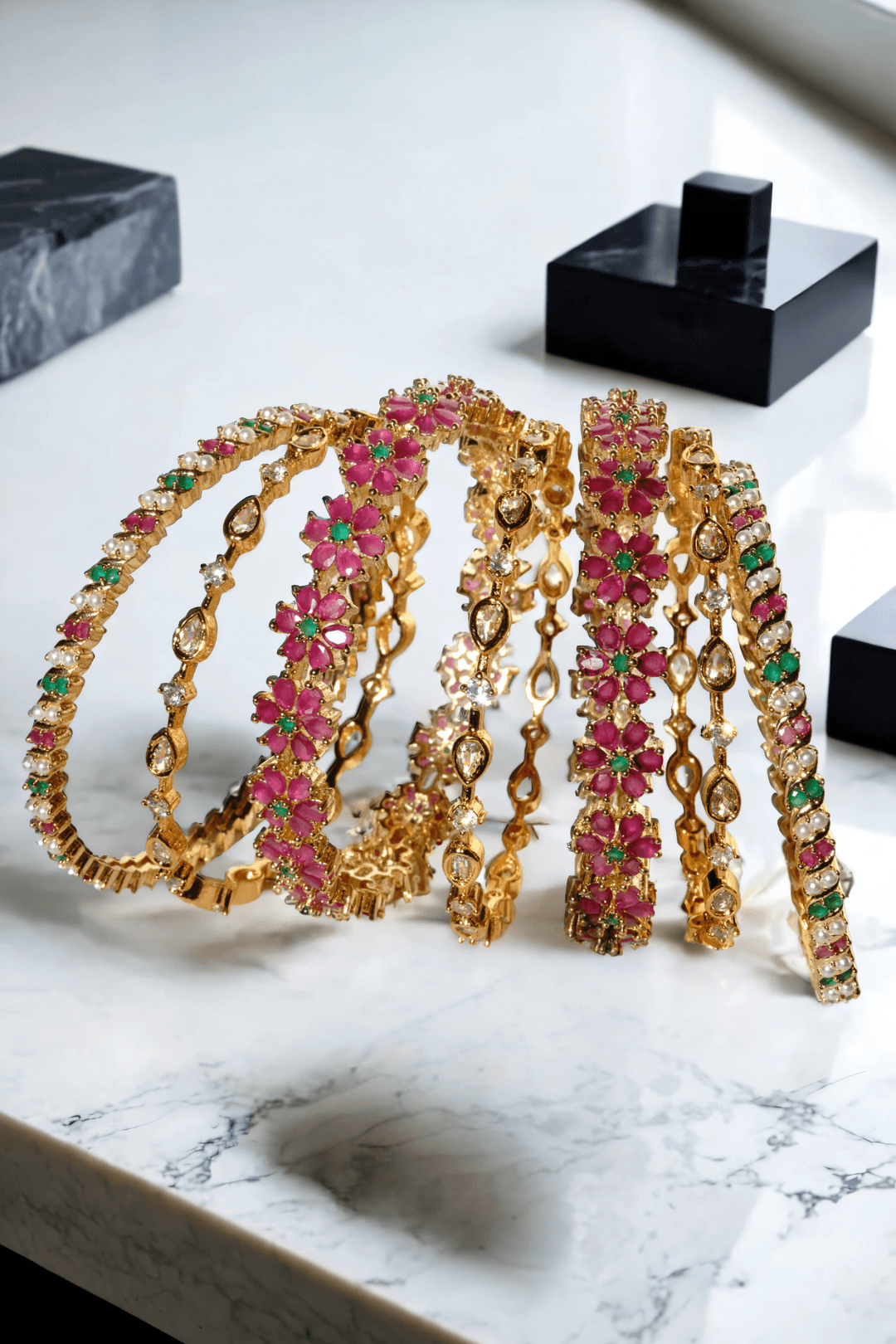 Meera 7-piece gold-plated bangle set with ruby and emerald accents from Inaury, floral design with diamante stones