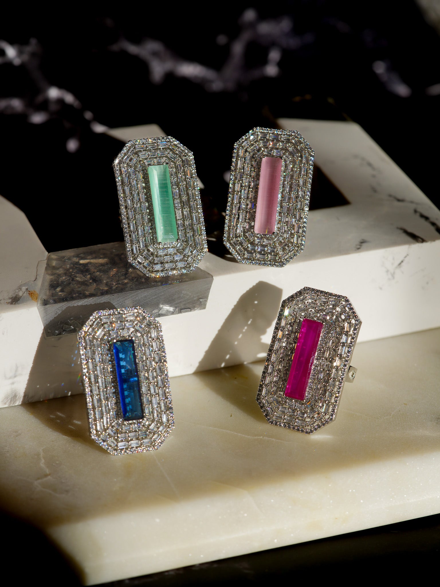 Sona Cocktail Rings- Indian Jewelry - Featuring four rhodium-plated rings with baguette-cut stones and colorful center stones.