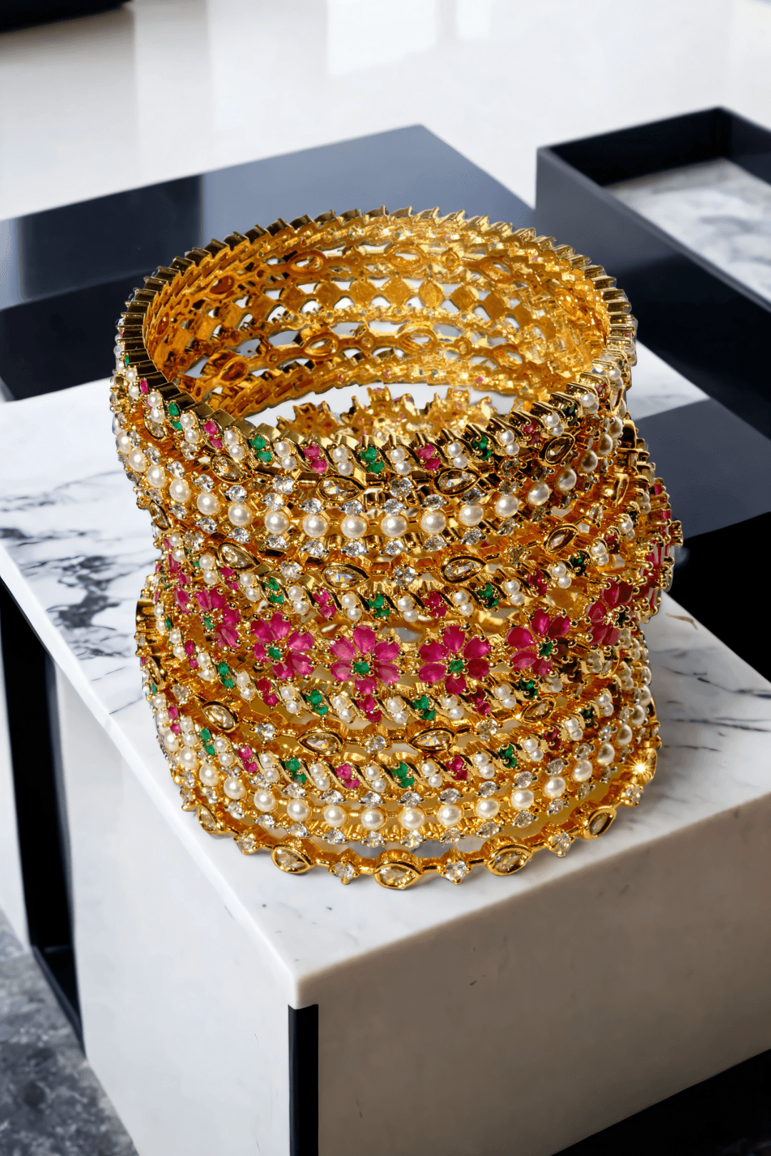 Tavisha 11-piece gold-plated floral and pearl bangle set with green and ruby accents.