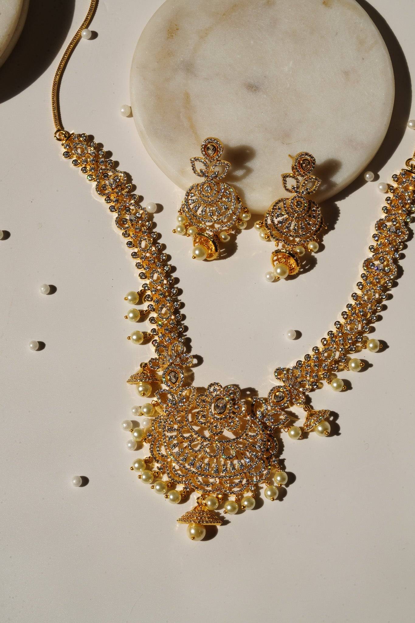 Anika Gold AD Necklace Set - Featuring intricate paisley and floral designs, hanging pearls, and matching dangler earrings.