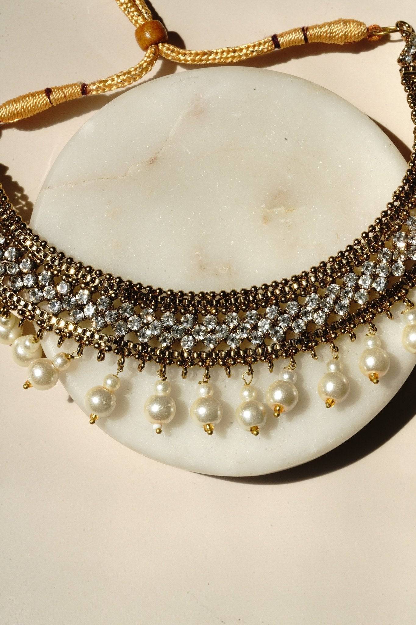 Arooj Handcrafted Pakistani Necklace Set - Antique gold-plated necklace, chandbali earrings, and maang tikka with pearl trim and sparkling white stones.